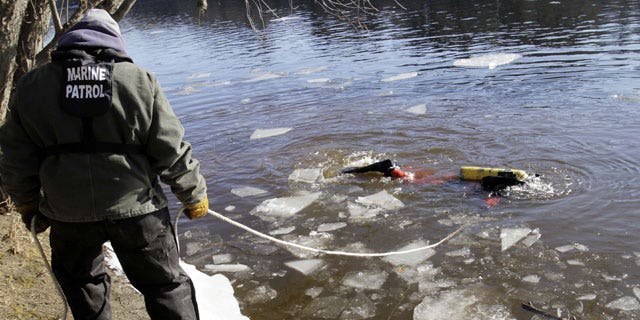 January 11, 2012: A diver maneuvers around sheets of ice as he searches the Kennebec River in Waterville, Maine for 20-month-old Ayla Reynolds who was reported missing since December.