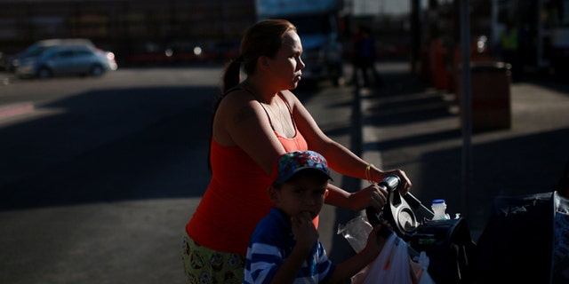 CALEXICO, CA - NOVEMBER 19: A family walks by the U.S. - Mexico border wall on November 19, 2014 in Calexico, California. U.S. President Barack Obama plans to announce executive action on immigration reform Thursday Evening. As many as five million undocumented immigrants could, on a temporary basis, be granted work permits and exempted from deporation. (Photo by Sandy Huffaker/Getty Images)