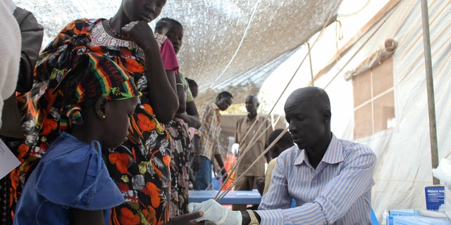 A displaced girl is tested for malaria at an MSF clinic in Tomping camp