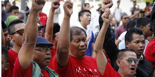 October 14, 2013: Muslim demonstrators chant slogans outside the Court of Appeal in Putrajaya, outside Kuala Lumpur, Malaysia, Monday. (AP Photo)