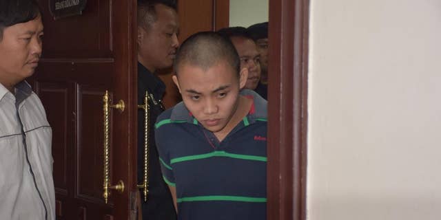 Zulkipli Abdullah, 23, center, walks out from a courtroom in Kuching, Malaysia, on Tuesday, March 31, 2015. On Tuesday, Prosecutor Muhamad Iskandar Ahmad said the high court found Zulkipli guilty of stabbing to death Aidan Brunger and Neil Gareth Dalton, two British medical students, on Borneo island last August. (AP Photo)