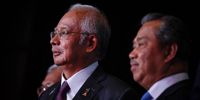 In this April 7, 2015 photo, Malaysian Prime Minister Najib Razak, left, and Deputy Prime Minister Muhyiddin Yassin attends the launch of the Malaysian Education Blue Print at a hotel in Kuala Lumpur, Malaysia. In an interview Thursday April 9, 2015, Najib pledged there will be no cover-up in the investigation of a debt-laden state investment fund and reiterated he is not involved in the murder of a Mongolian woman nine years ago. (AP Photo/Joshua Paul)