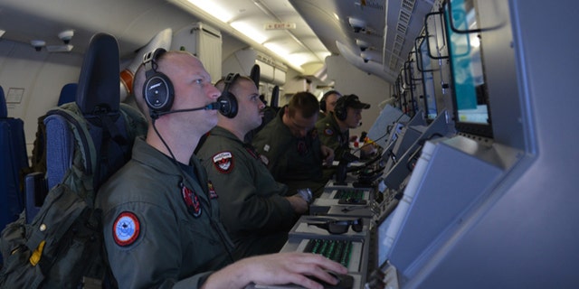 In this photo provided by the U.S. Navy, crew members on board an aircraft P-8A Poseidon assist in search and rescue operations for Malaysia Airlines flight MH370 in the Indian Ocean on Sunday, March 16, 2014. Malaysian authorities on Sunday examined a flight simulator that was confiscated from the home of one of the missing jetliner's pilots. The Boeing 777 went missing less than an hour into a March 8, flight from Kuala Lumpur to Beijing as it entered Vietnamese airspace. (AP Photo/U.S. Navy, Eric A. Pastor)