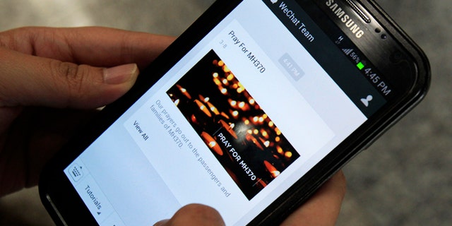 March 8, 2014: A message "Pray for MH370" is shown by mobile messaging app WeChat on a smartphone at Kuala Lumpur International Airport in Sepang, outside Kuala Lumpur, Malaysia.
