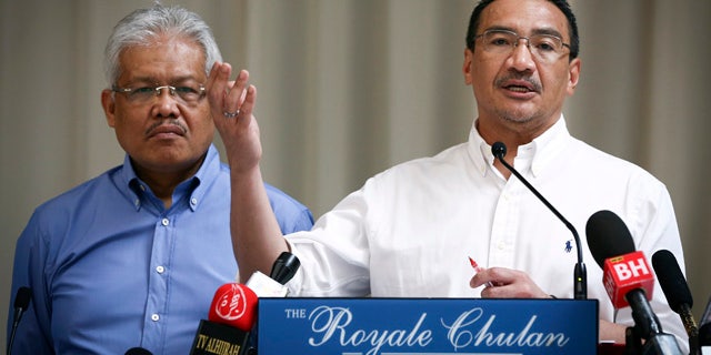 April 19, 2014: Malaysian Deputy Minister of Foreign Affairs Hamzah Zainudin, left, listens as Malaysia's acting Transport Minister Hishammuddin Hussein answers a question from a journalist during a press conference on the missing Malaysia Airlines Flight 370 at a hotel in Kuala Lumpur. (AP Photo/Vincent Thian)
