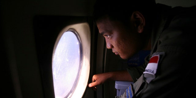 An Indonesian Navy crew member scans the water bordering Indonesia, Malaysia and Thailand during a search operation for the missing Malaysian Airlines Boeing 777 near the Malacca straits on Monday, March 10, 2014. Dozens of ships and aircraft have failed to find any piece of the missing Boeing 777 jet that vanished more than two days ago above waters south of Vietnam as investigators pursued "every angle" to explain its disappearance, including hijacking, Malaysia's civil aviation chief said Monday. (AP Photo/Binsar Bakkara)