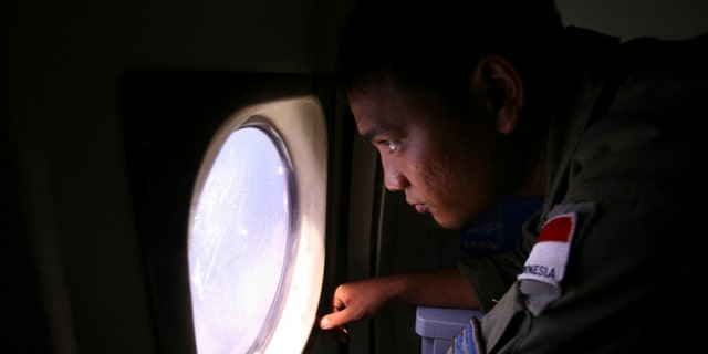 An Indonesian Navy crew member scans the water bordering Indonesia, Malaysia and Thailand during a search operation for the missing Malaysian Airlines Boeing 777 near the Malacca straits on Monday, March 10, 2014. Dozens of ships and aircraft have failed to find any piece of the missing Boeing 777 jet that vanished more than two days ago above waters south of Vietnam as investigators pursued "every angle" to explain its disappearance, including hijacking, Malaysia's civil aviation chief said Monday. (AP Photo/Binsar Bakkara)