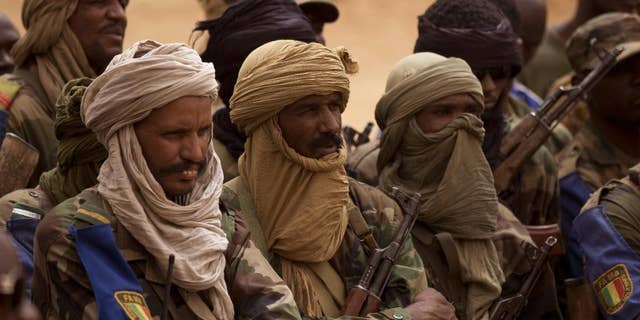 FILE - In this July 27, 2013 file photo, Malian Tuareg soldiers loyal to Col. Major El-Hadj Gamou listen during a visit by Mali's army chief of staff in Kidal, Mali. Tuareg separatist rebels agreed to sign a peace deal with the government in just over a week’s time but that hasn’t stopped them from attacking towns and encroaching further south toward Mali’s capital. The toll has risen to 30 dead in recent days. (AP Photo/Rebecca Blackwell, File)