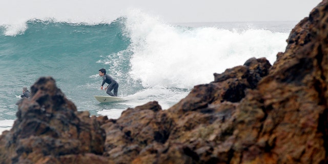 A surfer rides a wave by Point Dume in Malibu, California. Starting Wednesday, students at Malibu High School will be relocated from a campus building that teachers suspect has caused incidents of cancer (REUTERS/Mario Anzuoni)