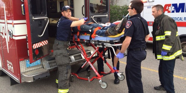 The suspect is transported on a gurney into an ambulance in Taunton, Mass., Tuesday, May 10, 2016.
