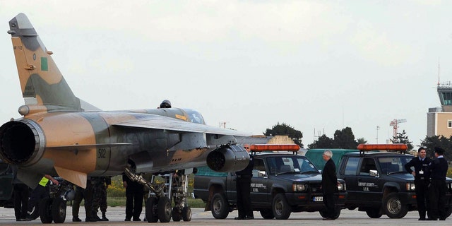 One of two Libyan Air Force Mirage jet fighters to land in Malta, is surrounded by Maltese police after it landed in Malta's International airport, Monday, Feb. 21, 2011.