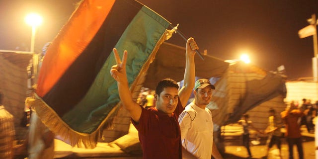 Aug. 22: A man flashes the victory sign as he celebrates the capture in Tripoli of Qaddafi's son and one-time heir apparent, Seif al-Islam, at the rebel-held town of Benghazi, Libya. It turned out that Seif al-Islam was not in custody and appeared Monday night in Tripoli.