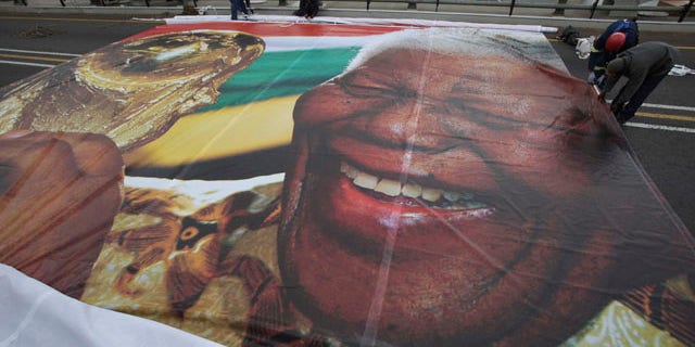 May 30: Workers prepare to hang an image of former President Nelson Mandela with the World Cup trophy on the Mandela bridge leading to downtown Johannesburg. (AP)