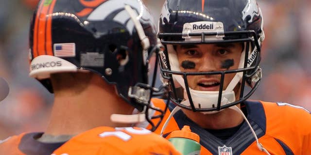 FILE - In this Sept. 29, 2013, file photo, Denver Broncos quarterback Brock Osweiler (17) talks with Peyton Manning (18) during an NFL football game against the Philadelphia Eagles in Denver. There was a time when Brock Osweiler, who's entering his third year of an extended apprenticeship under Peyton Manning, wanted to seek out Aaron Rodgers to pick his brain about how he learned under Brett Favre. Instead, he decided to figure it out for himself. (AP Photo/Jack Dempsey, File)
