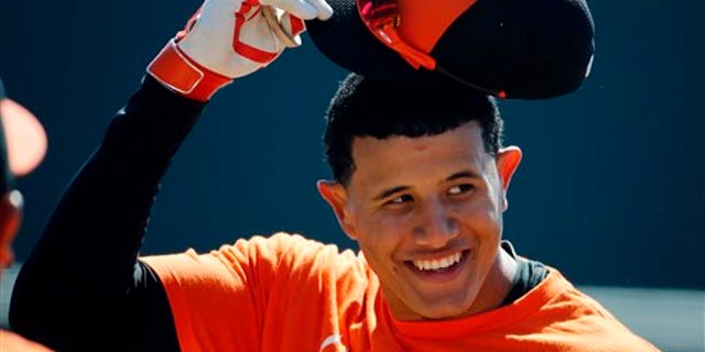 Baltimore Orioles' Manny Machado takes off his hat before going into the batting cage to hit before an exhibition spring training baseball game against the Boston Red Sox in Sarasota, Fla., Saturday, March 8, 2014. (AP Photo/Gene J. Puskar)