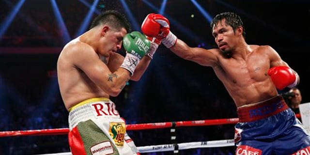 Manny Pacquiao, from the Philippines, right, punches Brandon Rios of the United States during their WBO international welterweight title fight Sunday, Nov. 24, 2013, in Macau. Pacquiao defeated Rios by unanimous decision on Sunday to take the WBO international welterweight title and return to his accustomed winning ways after successive defeats. (AP Photo/ Vincent Yu)