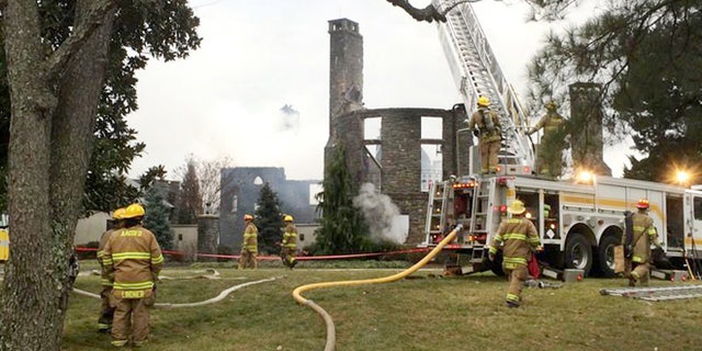 Firefights work to put out a fire at a home on Childs Point Road, Monday, Jan. 19, 2015, in Annapolis, Md. Six people, at first thought to be out of town, were unaccounted for Monday night after the fire that gutted the seven bedroom, 7 1/2 bath home. (AP Photo/The Baltimore Sun, Tim Pratt)