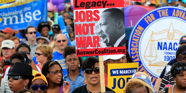 Demonstrators march towards the Martin Luther King Junior Memorial during the rally to commemorate the 50th anniversary of the 1963 March on Washington Saturday, Aug. 24, 2013, in Washington.