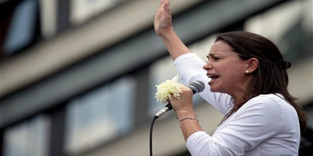 May 30, 2015: Opposition leader Maria Corina Machado holds a white flower as she speaks during an anti-government protest in Caracas, Venezuela.