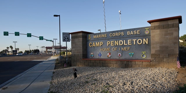 Vehicles file through the main gate of Camp Pendleton Marine Base on Wednesday, Nov. 13, 2013, at Camp Pendleton, Calif. Four Marines were reported killed today in an accident while clearing an unexploded ordnance. (AP Photo/Lenny Ignelzi)