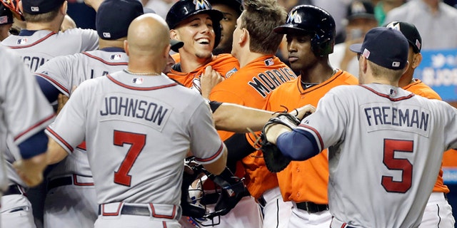 Miami Marlins starting pitcher Jose Fernandez is surrounded by Atlanta Braves players after an altercation broke out Wednesday, Sept. 11, 2013, in Miami.