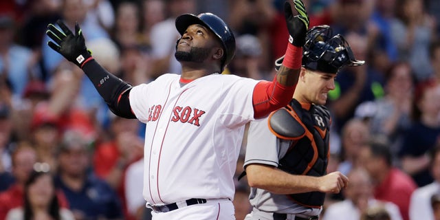 Boston Red Sox's David Ortiz reacts as he crosses home plate after his two-run home run during the third inning a baseball game at Fenway Park, Wednesday July 8, 2015, in Boston. At right is Miami Marlins catcher J.T. Realmuto. (AP Photo/Charles Krupa)