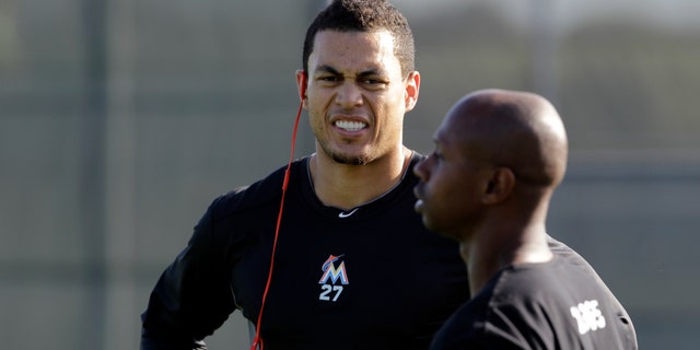 Miami Marlins outfielders Giancarlo Stanton, left, and Juan Pierre talk on a practice field in Jupiter, Fla., Feb. 12, 2013.