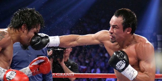 Juan Manuel Marquez, from Mexico, right, lands a right to the head of Manny Pacquiao, from the Philippines, during their WBO world welterweight  fight Saturday, Dec. 8, 2012, in Las Vegas. Marquez won by a knockout. (AP Photo/Julie Jacobson)