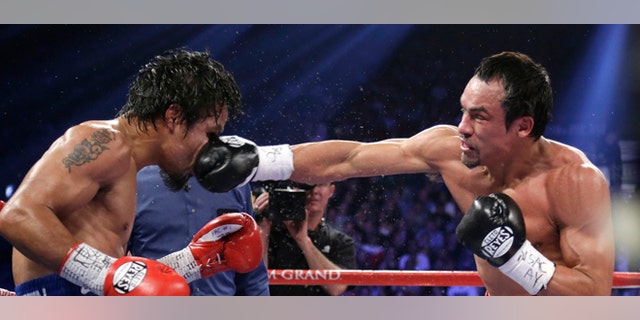 Juan Manuel Marquez, from Mexico, right, lands a right to the head of Manny Pacquiao, from the Philippines, during their WBO world welterweight fight Saturday, Dec. 8, 2012, in Las Vegas. Marquez won by a knockout. (AP Photo/Julie Jacobson)