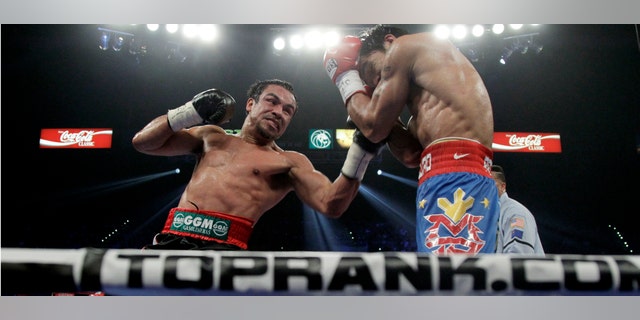 El filipino Manny Pacquiao, derecha, recibe un golpe de izquierda dal mexicano Juan Manuel Márquez durante la pelea por el título de peso welter de la OMB, el sábado 12 de noviembre de 2011, en Las Vegas. (Foto AP/Julie Jacobson)