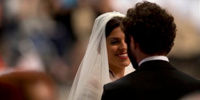 Alessandra Pucci smiles to Francesco Allotta after being married by Pope Francis, during a wedding ceremony in St. Peter's Basilica at the Vatican, Sunday, Sept. 14, 2014. Pope Francis married 20 couples Sunday, including some who already live together and those with children, technically a sin in the eyes of the church. (AP Photo/Alessandra Tarantino)
