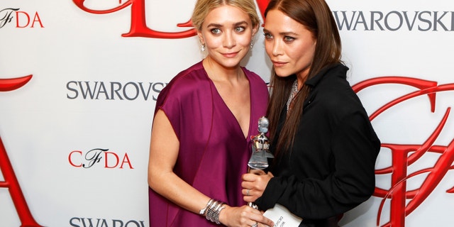Designers Ashley (L) and Mary-Kate Olsen smile backstage with their award for Womenswear Designer of the Year at the 2012 Council of Fashion Designers of America (CFDA) Fashion Awards in New York June 4, 2012.