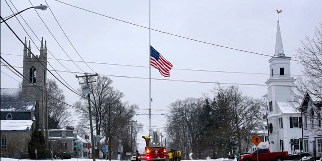 December 14, 2013: On the first anniversary of the Sandy Hook massacre, firefighters in Newtown, Conn. lower the town's flag on Main Street to half-staff in honor of the victims. (AP Photo/Robert F. Bukaty, File)