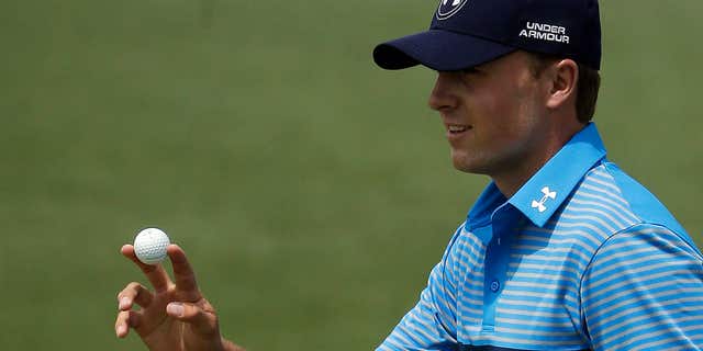 April 9, 2015: Jordan Spieth holds up his ball a birdie on the second hole during the first round of the Masters golf tournament.