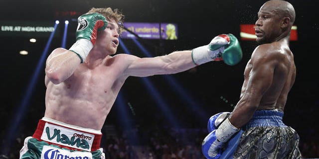 September 14, 2013: Canelo Alvarez throws a jab at Floyd Mayweather Jr. during a 152-pound title fight in Las Vegas. (AP Photo)