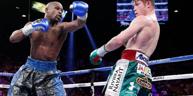 Floyd Mayweather Jr. throws a jab at Canelo Alvarez in the eighth round during a 152-pound title fight, Saturday, Sept. 14, 2013, in Las Vegas. (AP Photo/Eric Jamison)