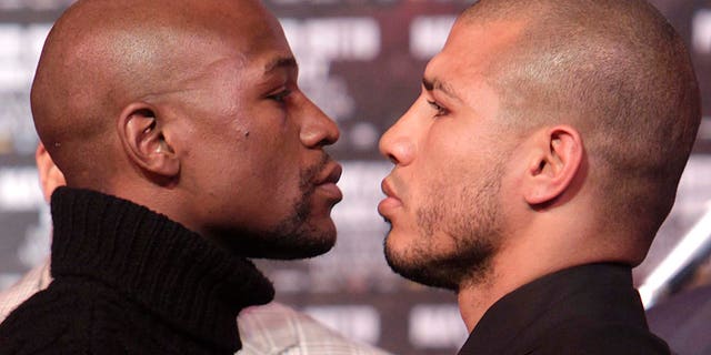 Boxers Floyd Mayweather, left, and Miguel Cotto face-off during a news conference in New York, Tuesday, Feb. 28, 2012.