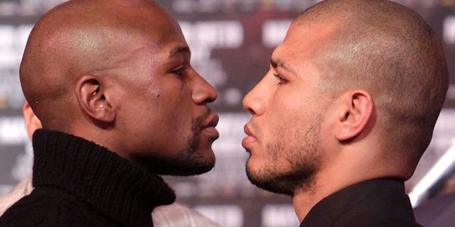 Boxers Floyd Mayweather, left, and Miguel Cotto face-off during a news conference in New York, Tuesday, Feb. 28, 2012.