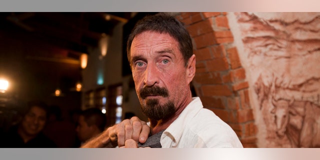 Software company founder John McAfee adjusts a microphone in preparation for an interview in Guatemala City, Tuesday, Dec. 4, 2012. McAfee, 67, has been identified as a "person of interest" in the killing of his neighbor in Belize, 52-year-old Gregory Faull. Police are urging McAfee to come in for questioning. The anti-virus company founder fled Belize and is seeking political asylum in Guatemala, according to his lawyer Telesforo Guerra. (AP Photo/Moises Castillo)