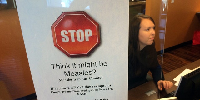 FILE - In this Feb. 7, 2015, file photo, a sign warns of the dangers of measles in the reception area of a pediatrician's office in Scottsdale, Ariz., Saturday, Feb. 7, 2015. Arizona officials are threatening legal action against an immigration detention center south of Phoenix where an outbreak of measles has affected 22 this year, Thursday, July 7, 2016. (AP Photo/Tom Stathis, File)
