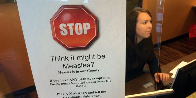 FILE - In this Feb. 7, 2015, file photo, a sign warns of the dangers of measles in the reception area of a pediatrician's office in Scottsdale, Ariz., Saturday, Feb. 7, 2015. Arizona officials are threatening legal action against an immigration detention center south of Phoenix where an outbreak of measles has affected 22 this year, Thursday, July 7, 2016. (AP Photo/Tom Stathis, File)