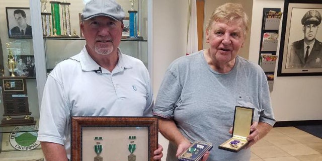 Lenny Kurtz and Jeffrey Simon pose with their war medals after Simon was reunited with his lost Purple Heart.