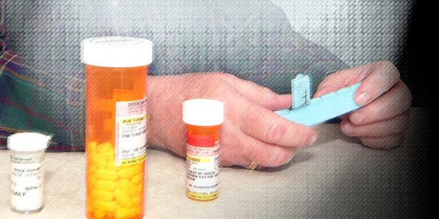 Don Brock of Litchfield, Minn., looks at some of his prescription drugs at his home in Litchfield, Minn. Friday, Feb. 10, 2006. Brock quit buying prescription drugs from Canada this year, now that he's signed up for the new federal Medicare drug benefit. (AP Photo/Bill Zimmer)