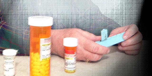 Don Brock of Litchfield, Minn., looks at some of his prescription drugs at his home in Litchfield, Minn. Friday, Feb. 10, 2006. Brock quit buying prescription drugs from Canada this year, now that he's signed up for the new federal Medicare drug benefit. (AP Photo/Bill Zimmer)