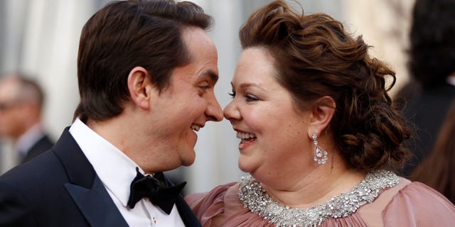 Melissa McCarthy, best supporting actress nominee for her role in "Bridesmaids," and her husband, Ben Falcone, arrive at the 84th Academy Awards in Hollywood, California, February 26, 2012. REUTERS/Lucy Nicholson (UNITED STATES) (OSCARS-ARRIVALS)