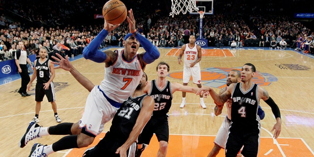 New York Knicks forward Carmelo Anthony (7) shoots a layup against San Antonio Spurs forward Tim Duncan (21) as guard Tony Parker (9), forward Tiago Splitter (22) and guard Danny Green (4) watch in the first half of their NBA basketball game at Madison Square Garden in New York, Thursday, Jan. 3, 2013. Anthony scored 23 points as the Knicks won 100-83. (AP Photo/Kathy Willens)