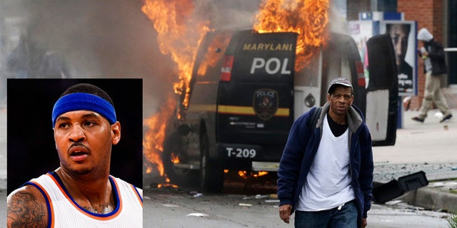 Un sujeto camina cerca de un vehÃculo policial incendiado el lunes 27 de abril de 2015, durante los disturbios que se dieron tras el funeral del negro Freddie Gray en Baltimore. Gray falleció de lesiones vertebrales una semana después de ser arrestado y trasladado en una camioneta del Departamento de PolicÃa de Baltimore. (Foto AP/Patrick Semansky)