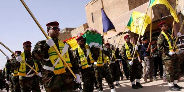 In this June 5, 2013 photos, members of Hezbollah Iraq march during a funeral in Kerbala, 70 miles south of Baghdad.