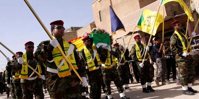 In this June 5, 2013 photos, members of Hezbollah Iraq march during a funeral in Kerbala, 70 miles south of Baghdad.
