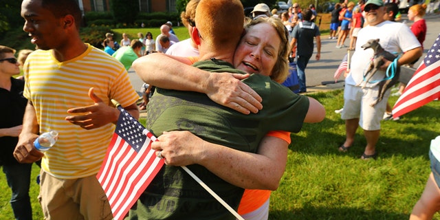 May 25, 2014: Neighbor Kathy Batton hugs Purple Heart recipient Lance Cpl. Alex Juedes, who was severely injured in Afghanistan in January of this year, as he gets a hero's welcome from friends, family and neighbors arriving home on the eve of Memorial Day in Marietta, Ga.